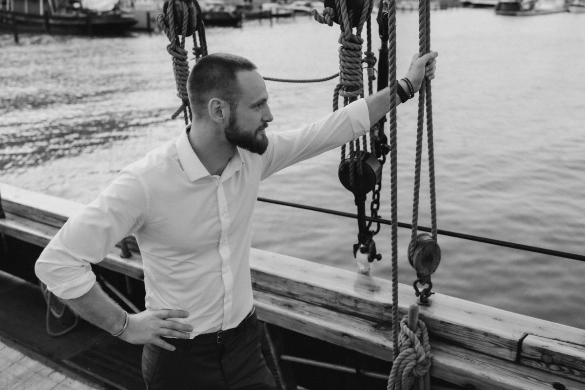 Bastian aboard a tall ship looking out over the water